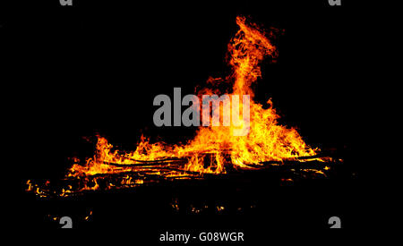 rote Flammen des riesigen Lagerfeuer oder Lagerfeuer als schwarze Migrationshintergrund Stockfoto