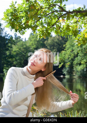 schöne Frau Kämme langes Haar in den Sommertag Stockfoto