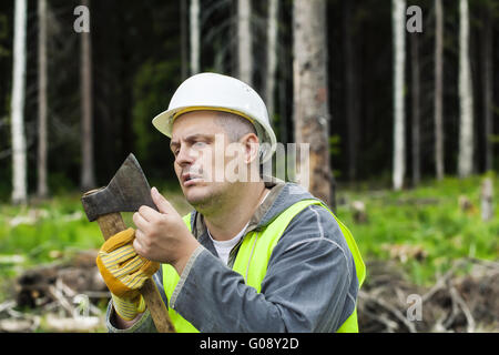 Holzfäller, die Überprüfung der Schärfe der Axt im Wald Stockfoto