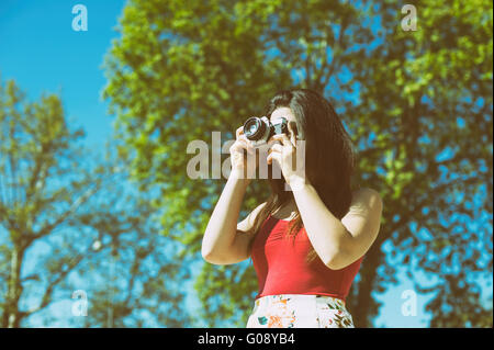 Junge Frau nehmen Foto mit Vintage-Kamera im freien Stockfoto