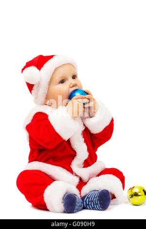 Kleiner Weihnachtsmann mit Spielzeug und Kugeln in Händen Stockfoto
