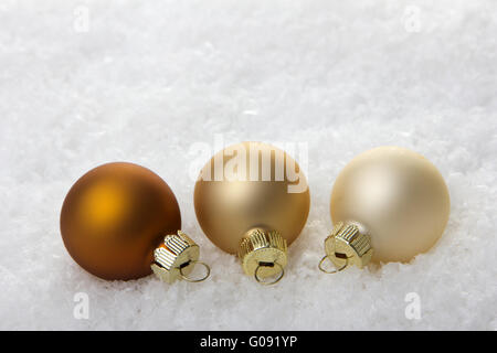 Braun, Creme-Weihnachtskugeln auf Kunstschnee Stockfoto