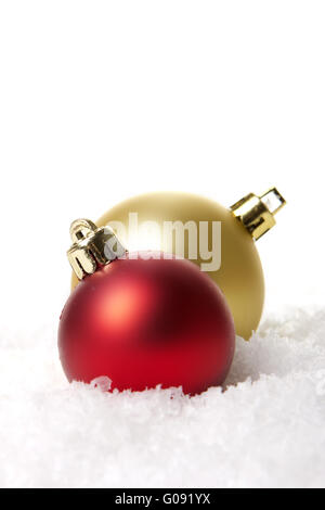 rote und goldene Weihnachtskugeln auf Kunstschnee Stockfoto