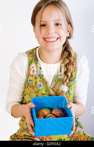 Junges Mädchen präsentieren eine Box mit bemalten Eiern Stockfoto