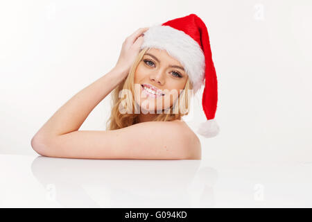 Junge Frau in Santa Claus Hut posiert isoliert auf weiss Stockfoto