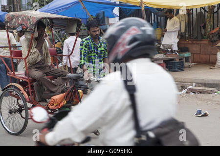 Fahrer eines Motorrades überqueren eine Rikscha, Dehli Stockfoto