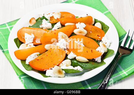 Spinat Persimmon Ziegenkäse Salat mit Mandeln Stockfoto