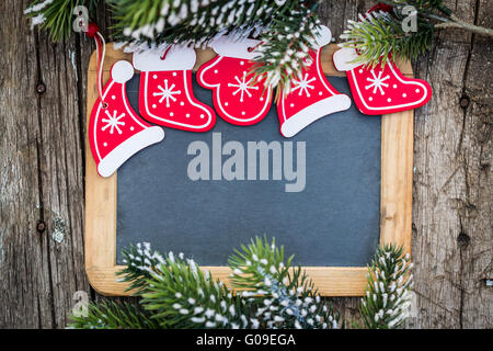 Leere Tafel eingerahmt in schönen Weihnachtsbaum Äste und Dekorationen Stockfoto