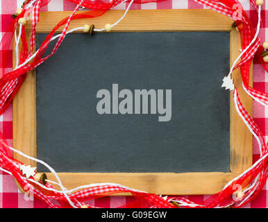 Leere Tafel eingerahmt in roter Weihnachtsschmuck Stockfoto