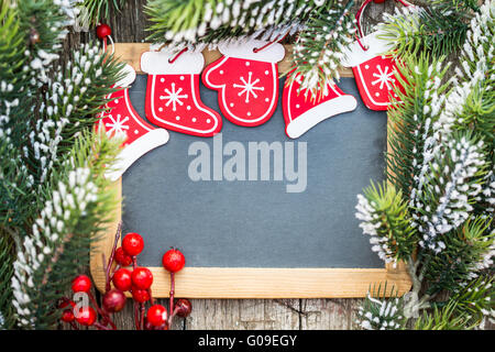 Leere Tafel eingerahmt in schönen Weihnachtsbaum Äste und Dekorationen Stockfoto