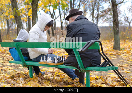 Drei Generationen einer Familie spielt Schach im Park beanch Stockfoto