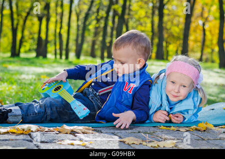 Kleinkinder, die Verlegung auf dem Boden in einem Park Stockfoto