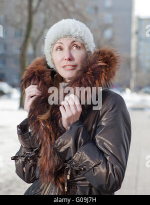 Frau in einer Jacke mit Fellkragen auf der Straße Stockfoto