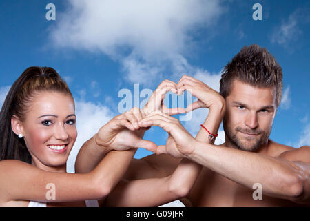 Junges Paar hat Hände in Form eines Herzens verbunden. Stockfoto