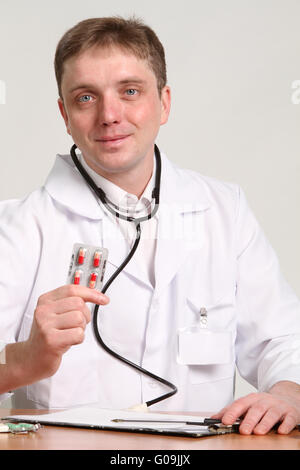 männlichen Arzt hält eine Pille auf weißem Hintergrund Stockfoto