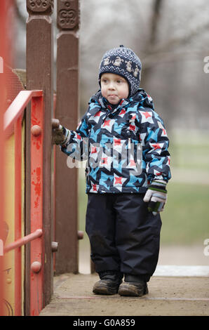 Niedliche kleine Junge in trendigen Winterkleidung gekleidet Stockfoto