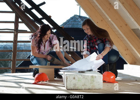 Zwei junge Frau, die Reparatur des Daches des Hauses Stockfoto