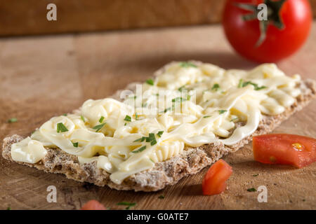 Knäckebrot mit Käse, Tomaten und Kräuter auf hölzernen Hintergrund. Gesundes Frühstück. Stockfoto