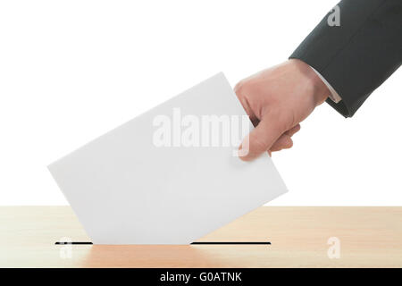 Die Hand des Mannes auf dem Stimmzettel in die Wahlurne. Stockfoto