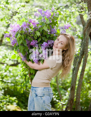 Frau im Park mit einem großen Blumenstrauß ein lila Stockfoto