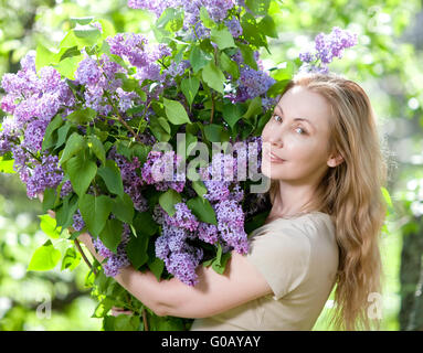 junge Frau im Park mit einem großen Blumenstrauß ein lila Stockfoto