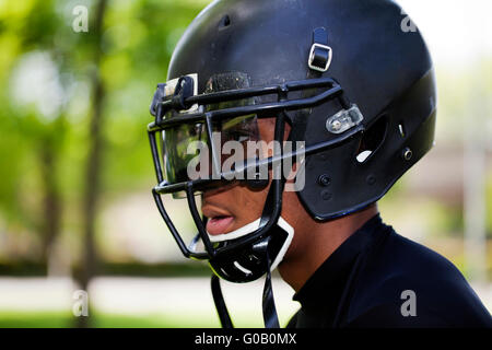 African American Jüngling in US-Football-Helm Stockfoto
