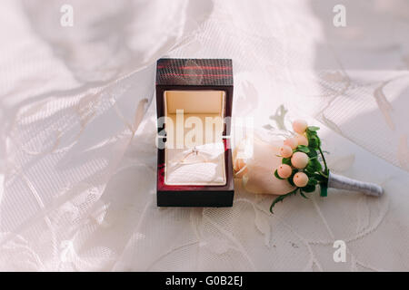 Goldenen Ehering in Box und Rosenblüten auf der Seite. Stockfoto