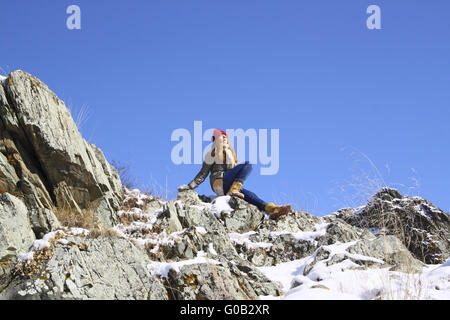 Junges Mädchen auf einem Felsen sitzt und meditiert Stockfoto