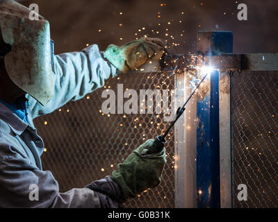 Arc Schweißgerät Arbeiter in Schutzmaske Schweißen Metall Stockfoto