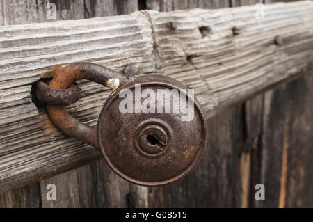 Alte rostige Vorhängeschloss auf verwitterten Holztüre closeup Stockfoto
