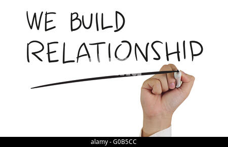 Motivationalen Konzept Bild einer Hand halten, Marker und schreiben wir bauen Beziehung isoliert auf weiss Stockfoto