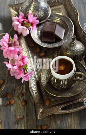 Bronze für türkischen Kaffee und blühenden Zweig gesetzt. Stockfoto