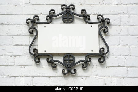 Typenschild im geschmiedeten Rahmen auf eine Mauer. Stockfoto