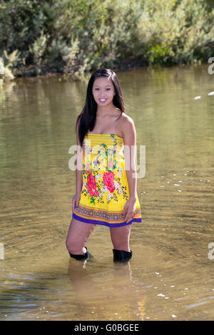 Junge Frau im Fluss Kleid Stiefel Stockfoto