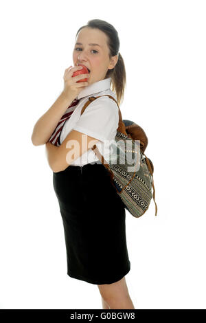 Junge Schülerin stehend einen Apfel essen Stockfoto