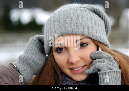 Junge Frau mit mobilen tragen Winter Kleidung Stockfoto