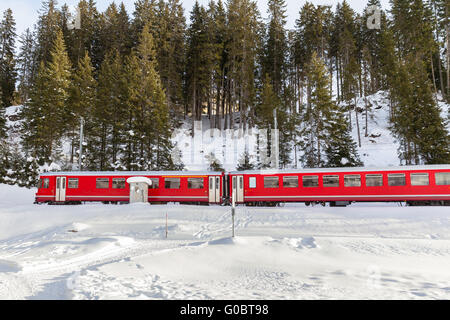 Berühmte Sehenswürdigkeiten Zug der Rhätischen Bahn laufen im Schnee, im Glacier-Express im Winter der Schweiz Stockfoto