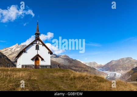 Die kleine Kapelle auf dem Berg des Dorfes Belalp mit Blick auf den Aletschgletscher im Hintergrund, Kanton Wallis, Schweiz Stockfoto