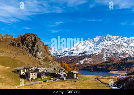 Atemberaubende Aussicht auf das Dorf Grevasalvas mit dem Silser See, Schweizer Alpen und goldene Bäume im Hintergrund, Oberengadin in au Stockfoto