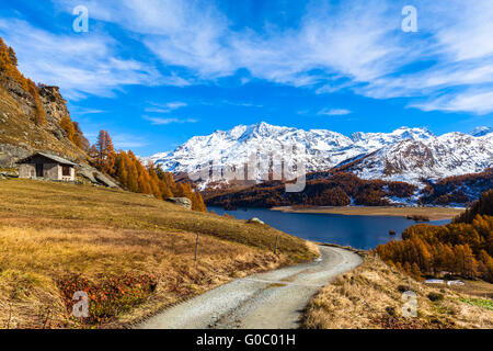 Atemberaubende Aussicht auf dem Wanderweg der Dorf-Grevasalvas in Richtung Sils See und die Schweizer Alpen im Oberengadin mit goldenen Stockfoto