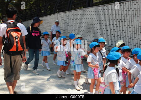 Schülerinnen und Schüler Gruppe zu Fuß in einem Park zusammen mit ihren Erziehern. Stockfoto