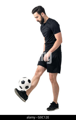 Seitenansicht des Freestyle Soccer oder Futsal-Spieler jonglieren Ball mit den Beinen. Ganzkörper-Länge-Porträt isoliert auf weiss Stockfoto