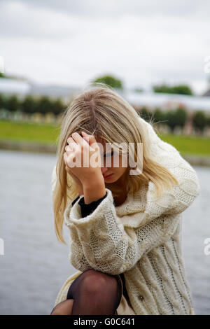 Das Mädchen in Verzweiflung und Trauer gegen den Fluss Stockfoto