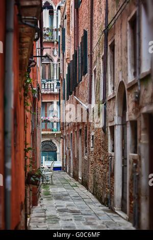 Schmale Straße unter alten bunten Ziegel Häuser in Venedig Stockfoto