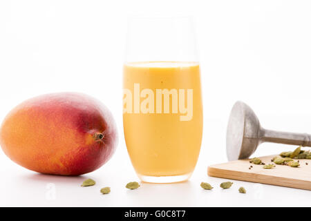 Ein Glas Mango Lassi und eine ganze Frucht Stockfoto