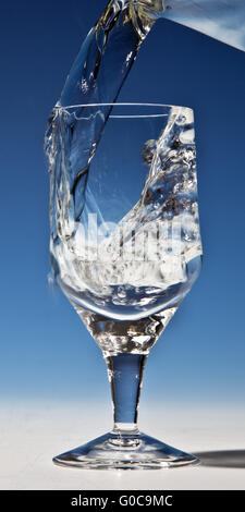 Wasser wird in ein Glas gegossen werden Stockfoto