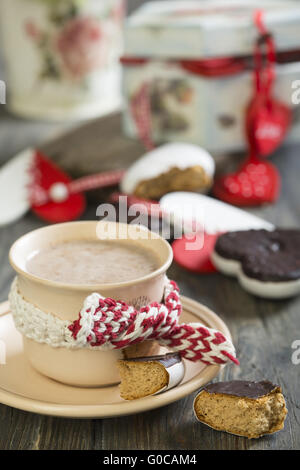 Tasse Kakao und Lebkuchen Herz auf Holztisch. Stockfoto