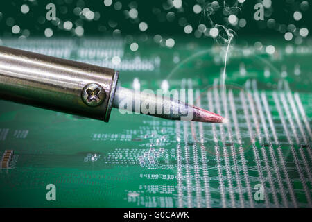 Rauchen Lötkolben auf einer Computer-Motherboard-Nahaufnahme Stockfoto