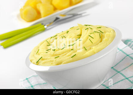 Schüssel mit gestampften Kartoffel-Püree mit gehackten Schnittlauch auf kariertes Geschirrtuch - Nahaufnahme Stockfoto