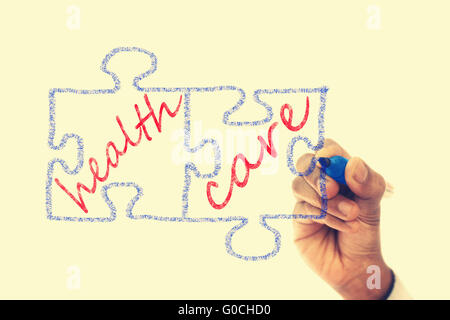 Puzzleteile geschrieben Gesundheitsversorgung werden auf transparente wischen Brett gezeichnet. Stockfoto